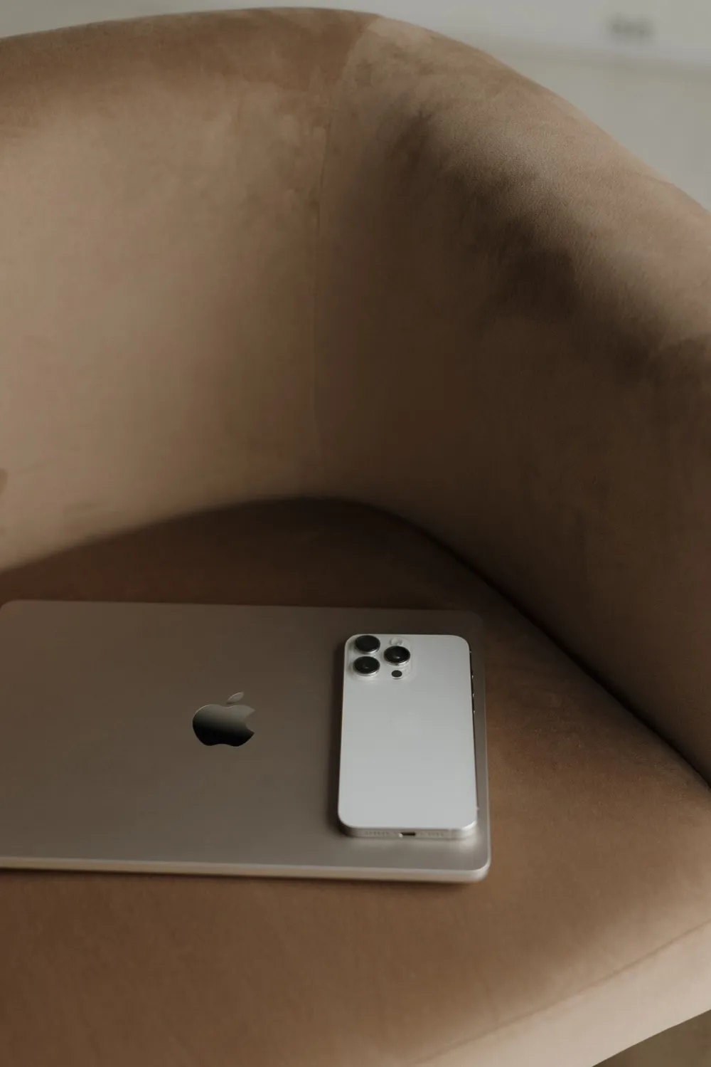 Laptop and phone on a velvet armchair