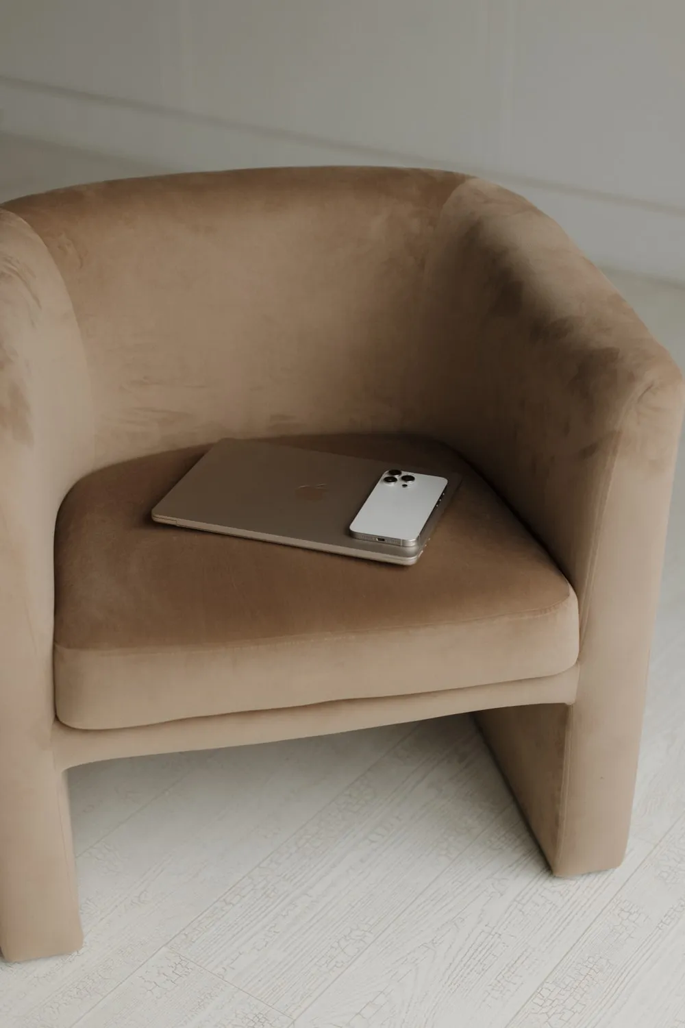Taupe velvet armchair with a laptop on the seat
