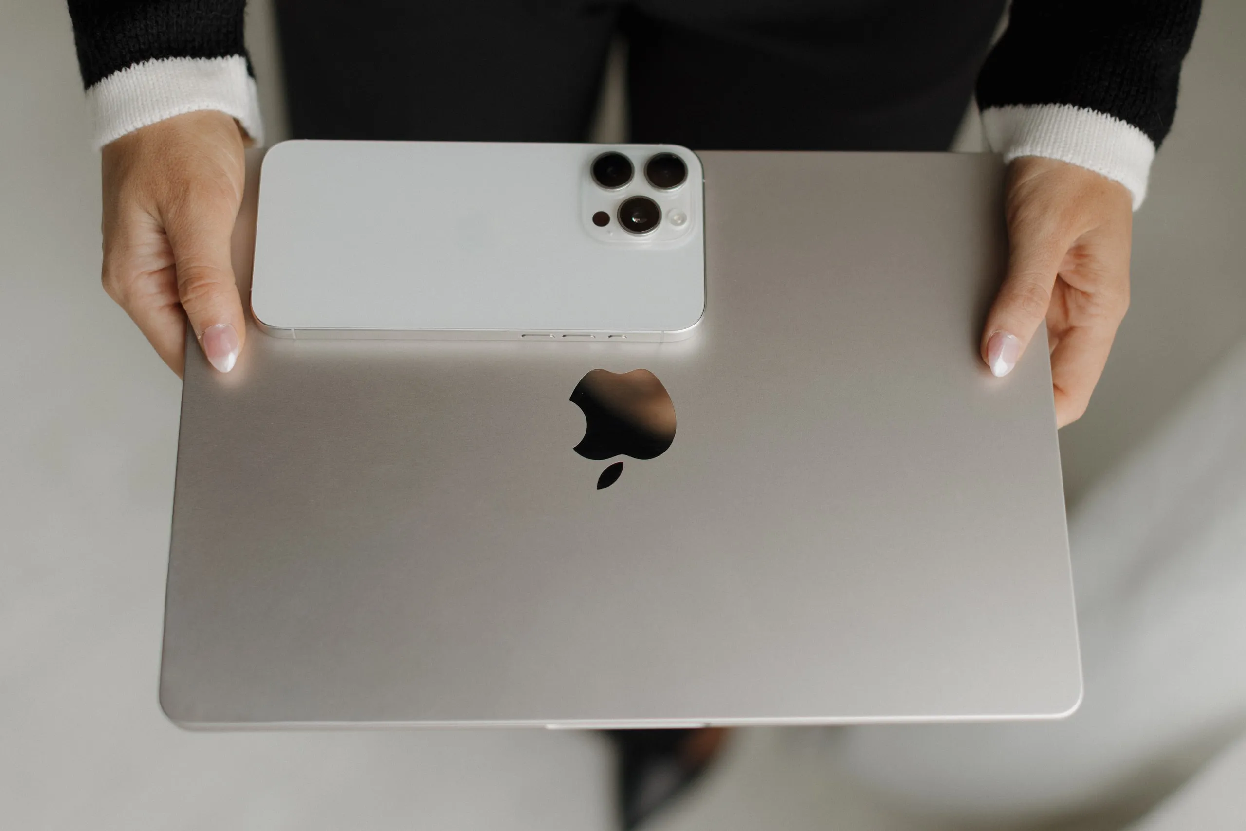 Laptop and phone held from above