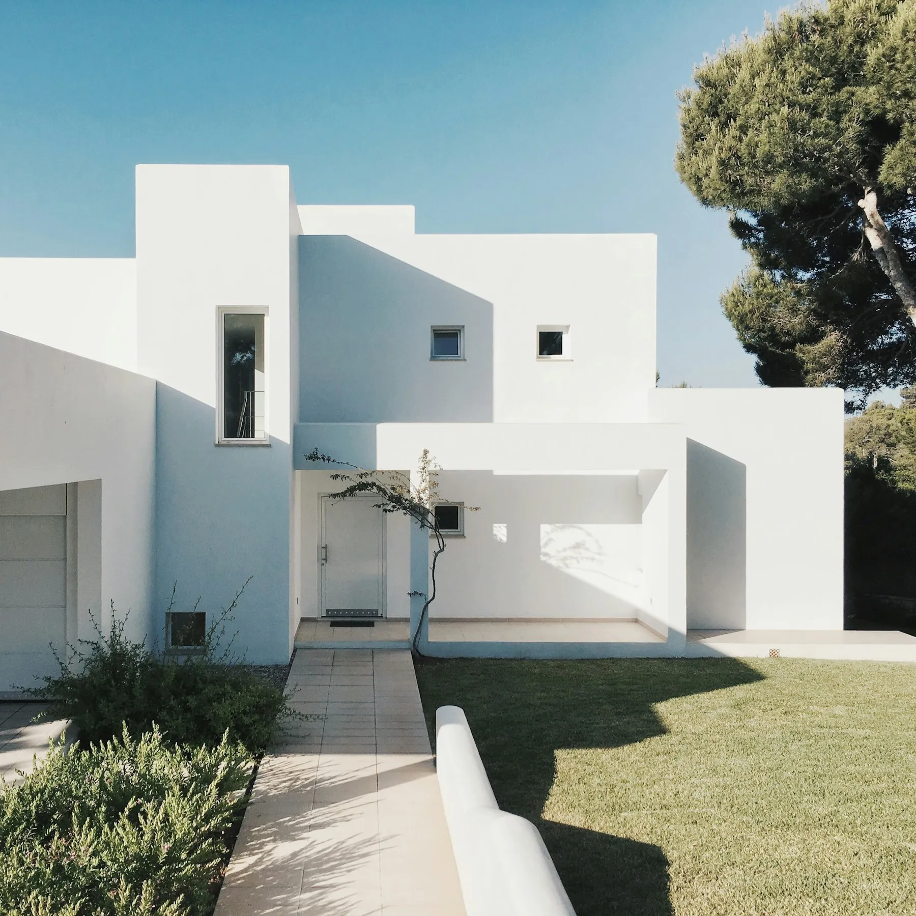 White modern home with a pine tree