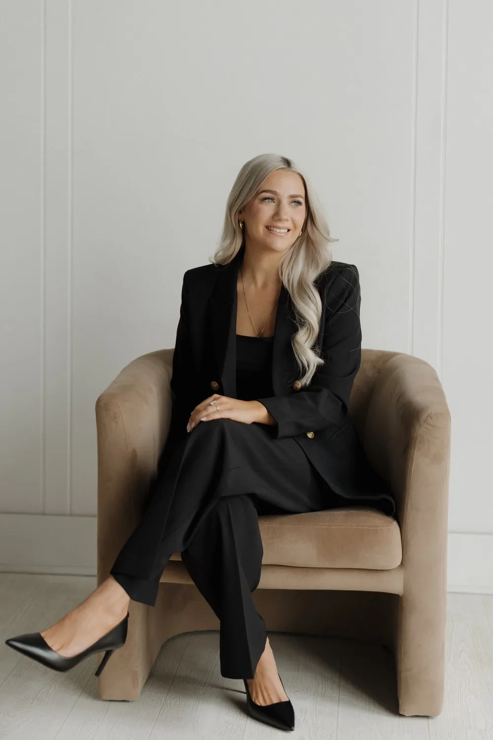 Marissa Lubera, Realtor, seated in a velvet armchair