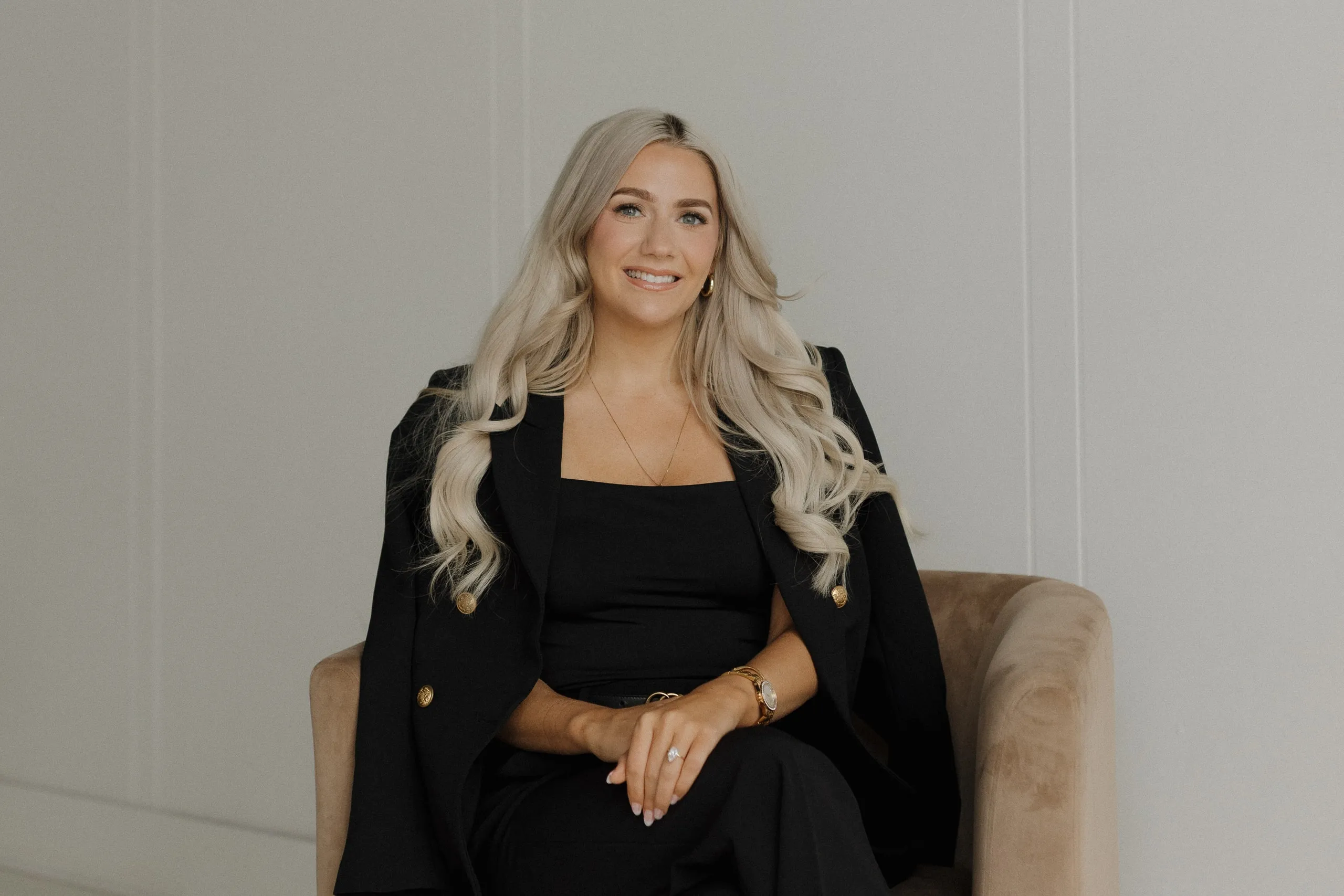 Marissa Lubera smiling in a velvet armchair